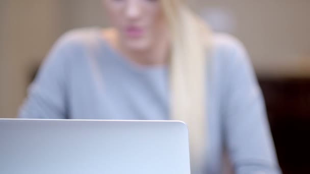 Uśmiechnięta młoda kobieta pracuje na laptopie - Materiał filmowy, wideo