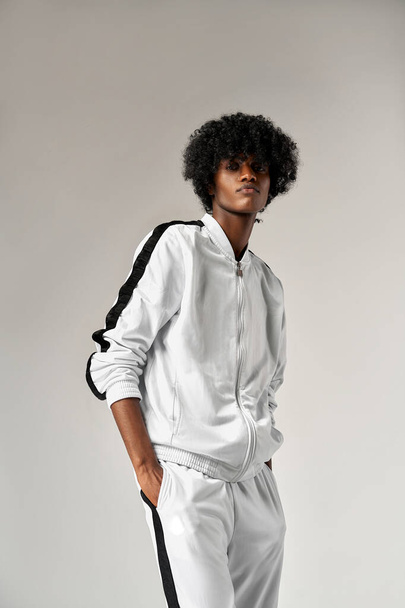Portrait of fashionable black man in white tracksuit - 写真・画像