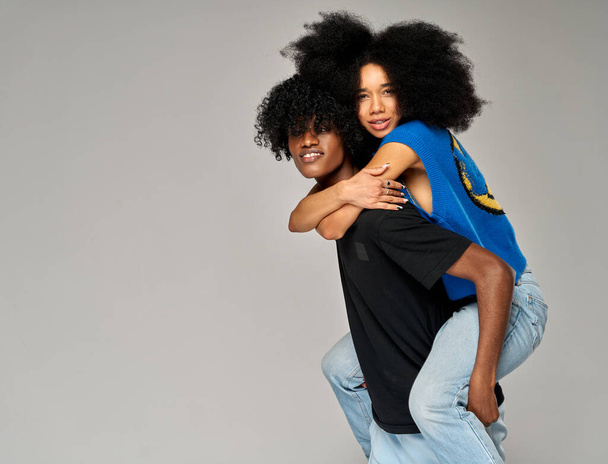 Portrait of lovely african american couple having fun while man piggybacking his girlfriend  - Foto, imagen