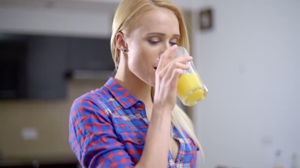 Mooie blonde vrouw drinken sap in een glas - Video