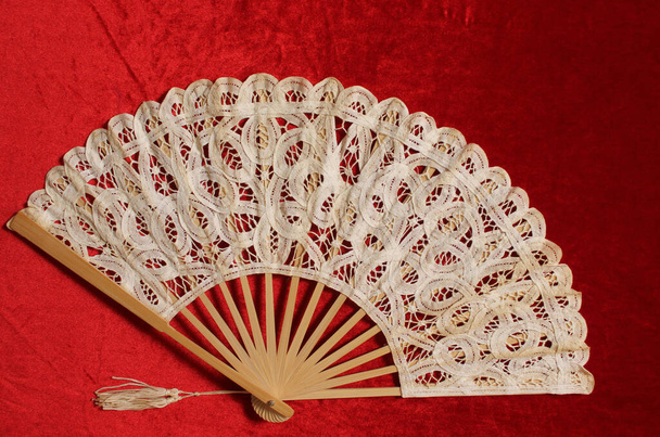 Vintage Cream Colored Lace Fan on Red Velvet Background - Photo, Image