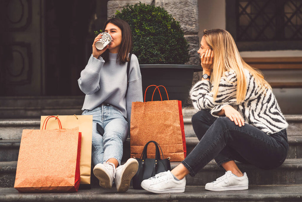 Two young caucasian women having fun on city street outdoors - Best friends enjoying a holiday day out together - Happy lifestyle, youth and young females concept. High quality photo - 写真・画像