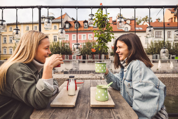 Dwie młode, kaukaskie kobiety bawiące się na ulicy miejskiej na świeżym powietrzu - Najlepsi przyjaciele cieszący się razem wakacyjnym dniem - koncepcja szczęśliwego stylu życia, młodzieży i młodych kobiet. Wysokiej jakości zdjęcie - Zdjęcie, obraz