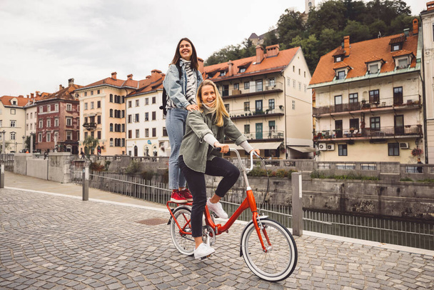 Zwei junge kaukasische Frauen amüsieren sich auf der Straße in der Stadt im Freien - Beste Freundinnen genießen einen gemeinsamen Urlaubstag - Happy Lifestyle, Jugend und junge Frauen Konzept. Hochwertiges Foto - Foto, Bild