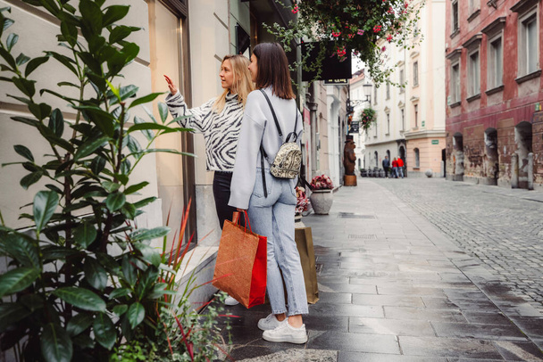 Two young caucasian women having fun on city street outdoors - Best friends enjoying a holiday day out together - Happy lifestyle, youth and young females concept. High quality photo - Photo, Image