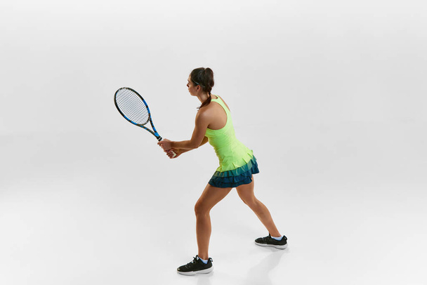 Portrait of young woman, professional female tennis player with racket against white studio background. Ready to play. Concept of professional sport, movement, health, action. Ad - Fotoğraf, Görsel