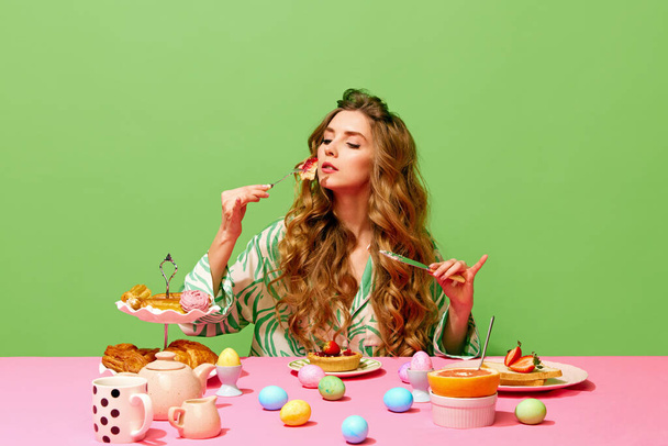 One pretty girl having family holiday dinner with manner face expression over green background. Concept of Easter holiday, traditions, food, breakfast, vintage, retro - Photo, Image