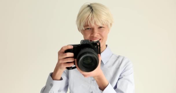 Жінка-журналістка робить фотографії з чорною професійною камерою на білому тлі 4k фільму повільний рух. концепція фотографії хобі
 - Кадри, відео