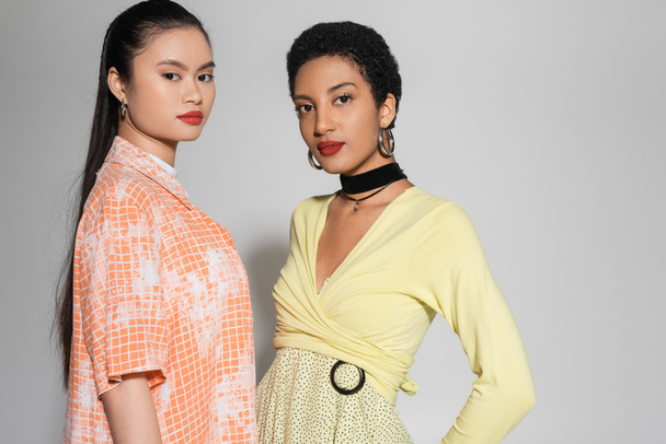 Stylish young interracial models with red lips looking at camera on grey background  - Φωτογραφία, εικόνα