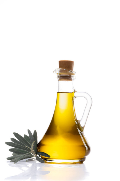 Organic olive oil in a glass jug with olive leaves on the side - 写真・画像