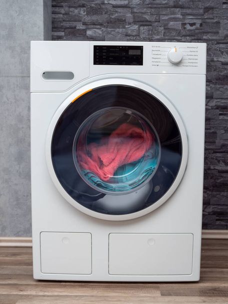 Modern washing machine against the wall. Laundry. Close-up. - Zdjęcie, obraz