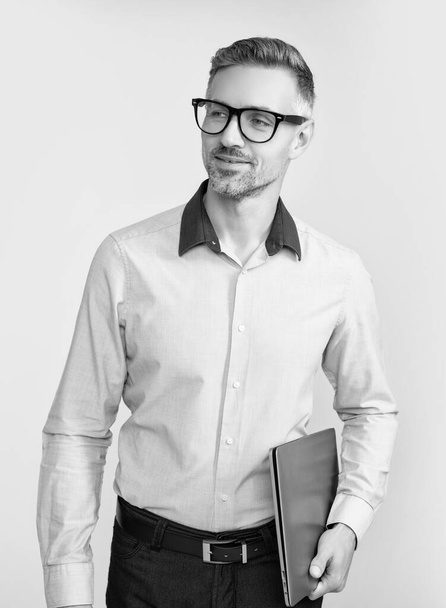 mature man in eyeglasses and shirt hold pc on grey background. - Valokuva, kuva