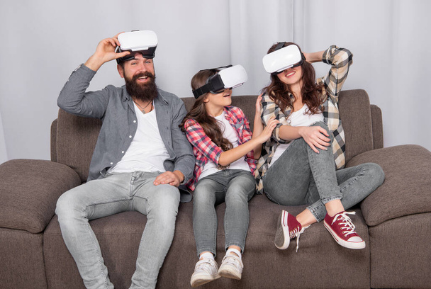 virtual reality family. happy parents with kid girl use modern technology. mom dad and daughter. digital future and innovation. father mother and child wireless VR glasses. - Фото, изображение