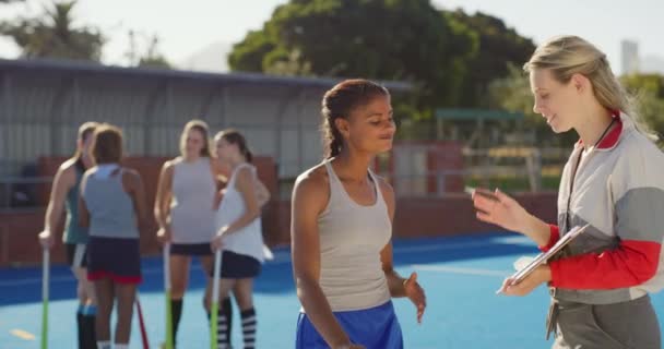 Coach and player high fiving. Beautiful woman coach talking to a young girl and motivating during practice. Happy hockey player giving a high fiving to her PE teacher during training on a sport court. - Footage, Video