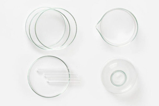 a set of laboratory glassware on a light background. Petri dishes, flasks, cups. - Фото, изображение