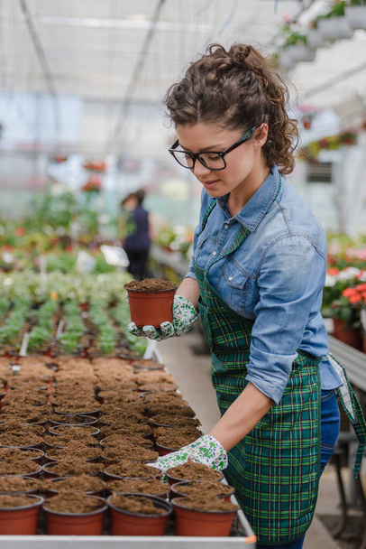 Молодая предпринимательница, работающая в цветочном саду - Фото, изображение