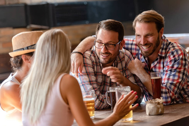 щасливі друзі п'ють пиво в кафе
 - Фото, зображення