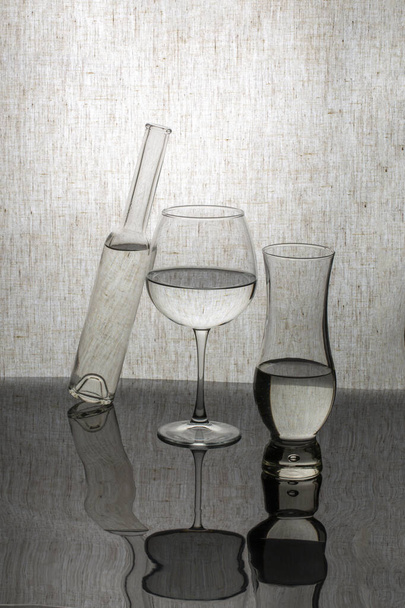 Asetelma lasiesineiden kanssa heijastavalla pinnalla - Valokuva, kuva