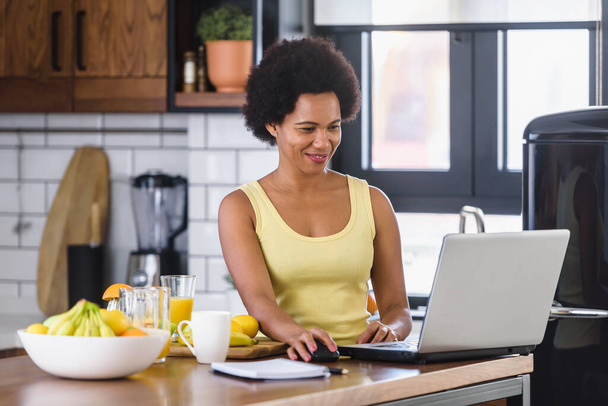 Afroamerykanka korzystająca z laptopa w domu  - Zdjęcie, obraz