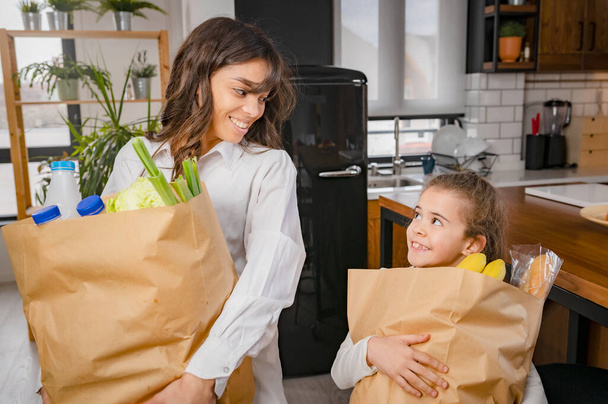 happy family with shopping bags at kitchen  - Φωτογραφία, εικόνα