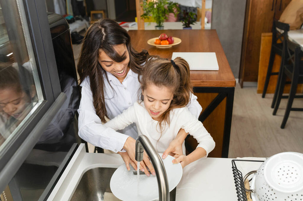 Madre e hija lavando los platos juntas
  - Foto, Imagen
