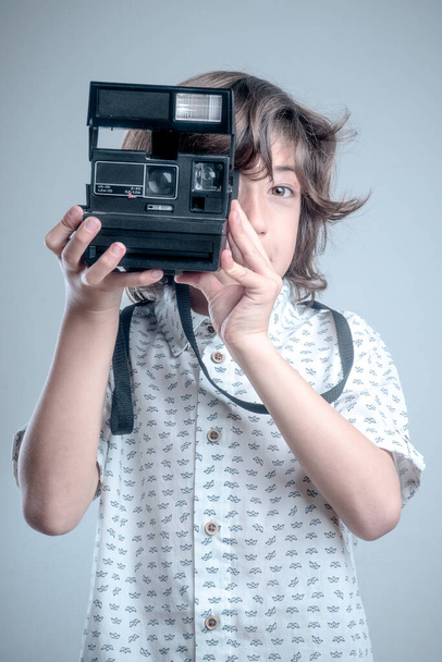 Junge mit weißem Hemd und blauen Details beim Fotografieren mit antiker Kamera. - Foto, Bild
