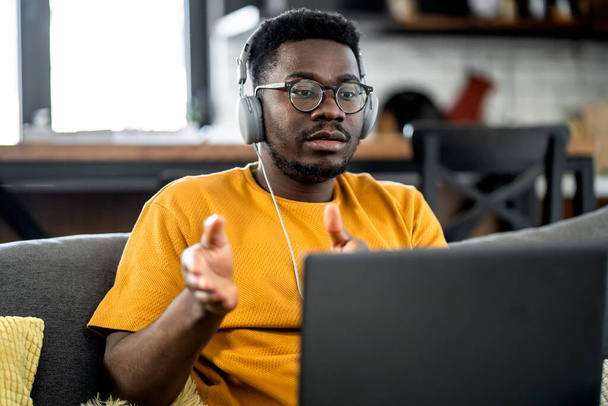 Afro-Amerikaanse man werkt op laptop  - Foto, afbeelding
