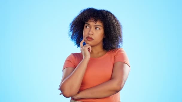 Twijfel, zwarte vrouw en denken met verwarring, ideeën en kansen met meisje tegen een blauwe studio achtergrond. Afro-Amerikaanse vrouw, dame en afvragen met onzekerheid, verward en attent. - Video