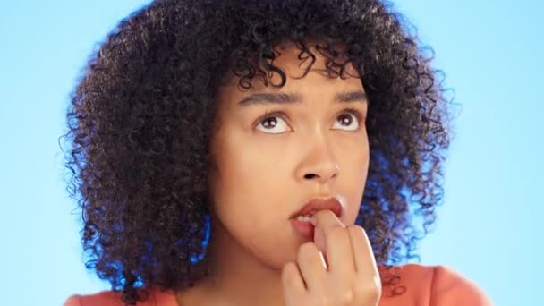 Siyahi kadın tırnaklarını yiyor, yüzüyle kaygılı ve gergin, zihinsel sağlık ve korku mavi arka planda izole edilmiş. Kadın korkuyor, krizi düşünüyor ya da stres ve endişe içinde stüdyoda.. - Video, Çekim