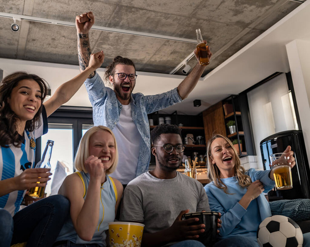 skupina přátel sledujících fotbalový zápas, oslavující vítězství a koncept přátelství - Fotografie, Obrázek