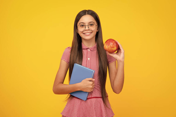Teen girl pupil hold books, notebooks, isolated on yellow background, copy space. Back to school, teenage lifestyle, education and knowledge - 写真・画像