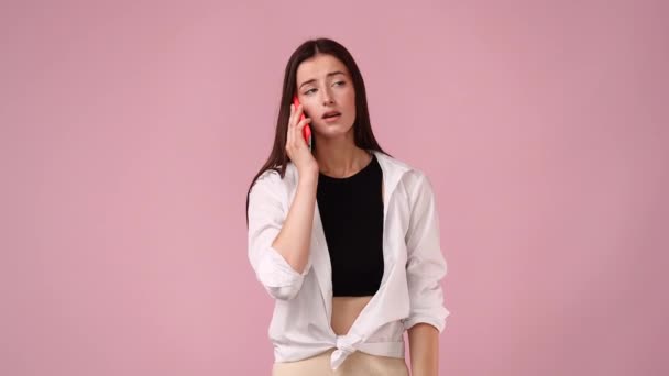 4k video of one girl talking on the phone over pink background. Concept of emotions. - Filmmaterial, Video