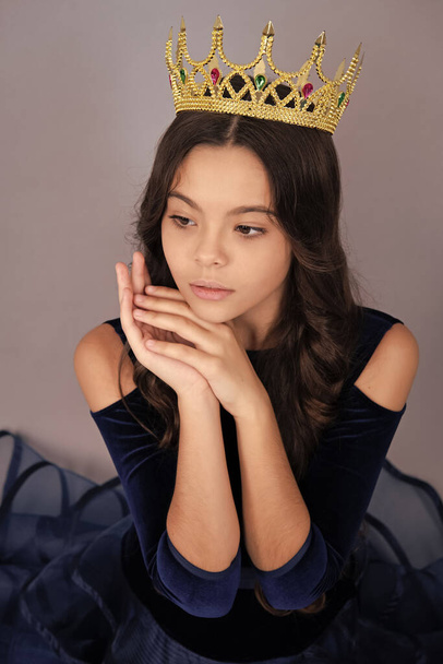 Teenager princess child celebrates success win and victory. Teen girl in queen crown isolated on grey background - Fotoğraf, Görsel
