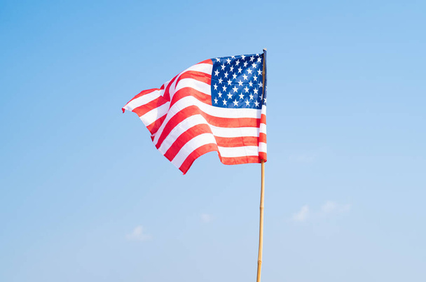 Amerika Birleşik Devletleri bayrağı rüzgarda dalgalanırken 4 Temmuz ya da Bağımsızlık Günü için izole edildi. Resmi vatanseverlik tasarımı. Mavi gökyüzü dalgalanırken. - Fotoğraf, Görsel