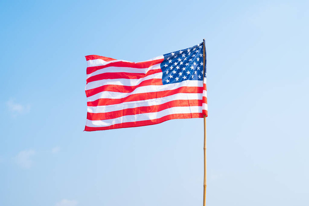 Bandera nacional de los Estados Unidos de América ondeando en el viento aislada para el 4 de julio o el Día de la Independencia. Diseño patriótico oficial. Señal ondeante con cielo azul. - Foto, imagen