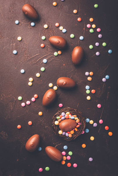Солодкий Великдень - шоколадні яйця та барвисті шоколадні боби в пташиному гнізді
 - Фото, зображення