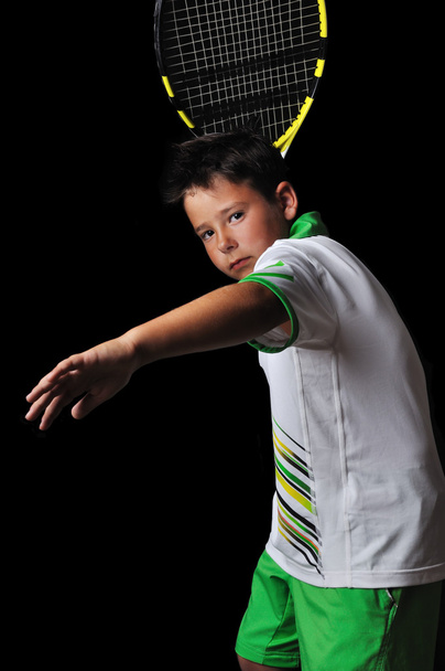 Tennis boy playing forehand isolated in black - 写真・画像