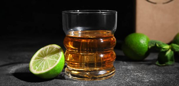 Bicchiere di rum con lime sul tavolo scuro - Foto, immagini