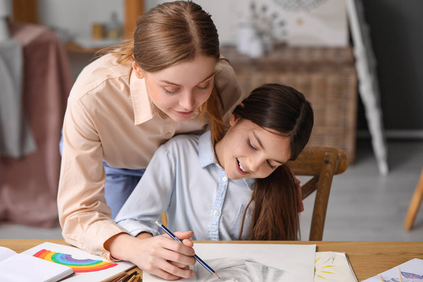 Piirustus opettaja lyijykynällä antaa yksityisen taiteen oppitunnin pikkutyttö työpajassa - Valokuva, kuva