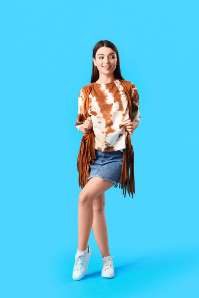 Stylish young woman in tie-dye t-shirt on light blue background - Photo, Image