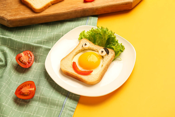 Bord met grappige toast en tomaten op gele achtergrond, close-up - Foto, afbeelding