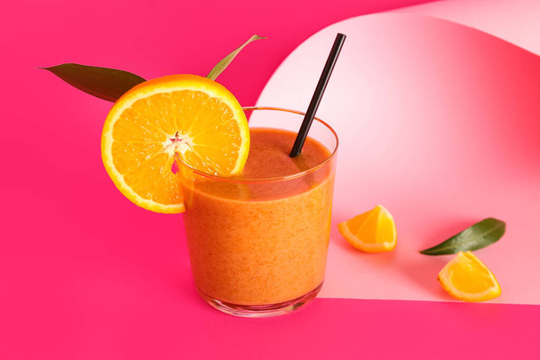 Стакан здорового смузи с апельсином на розовом фоне - Фото, изображение