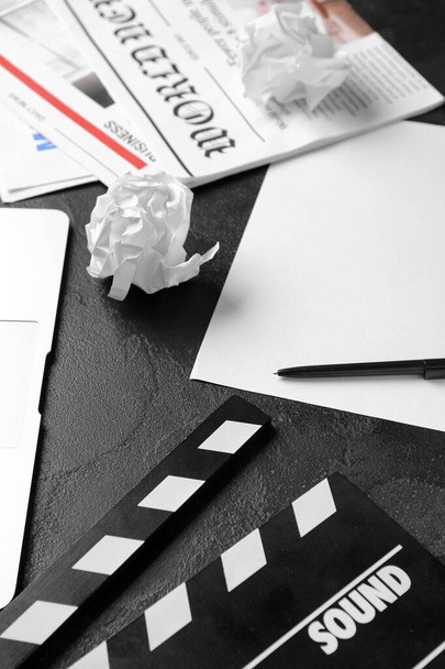 Бумажный лист с фильмом хлопок и газеты на темном фоне, крупным планом - Фото, изображение