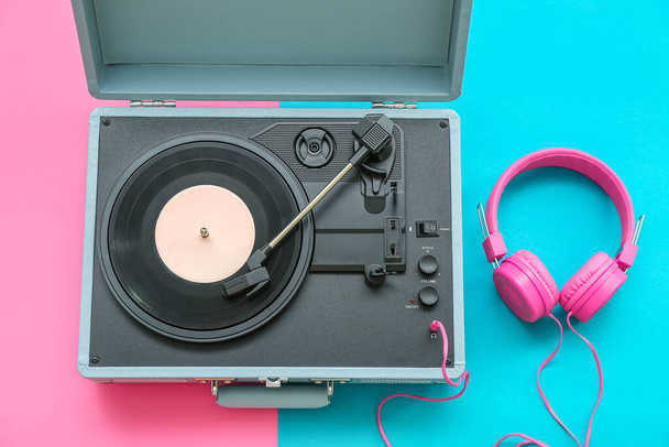 Record player con disco in vinile e cuffie su sfondo a colori - Foto, immagini