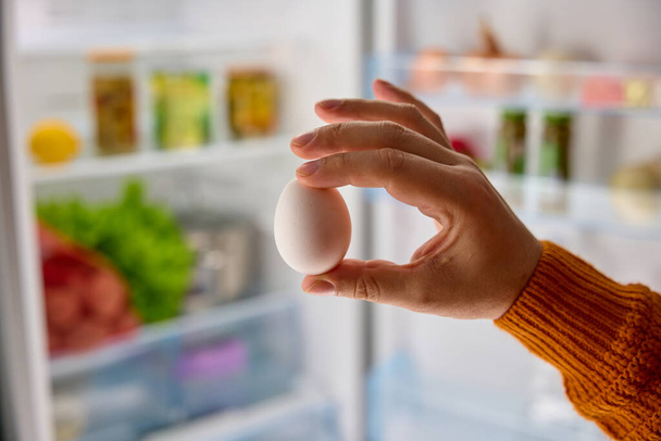 Erkek eli buzdolabından beyaz tavuk yumurtası alır. Yüksek kalite fotoğraf - Fotoğraf, Görsel