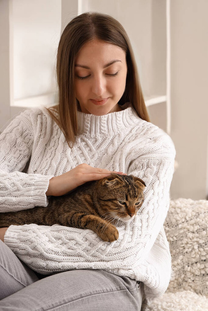 Jeune femme avec chat écossais rayé plié à la maison - Photo, image