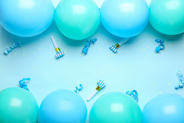 Rámeček z modrých balónků, stuh a party píšťaly na barevném pozadí - Fotografie, Obrázek