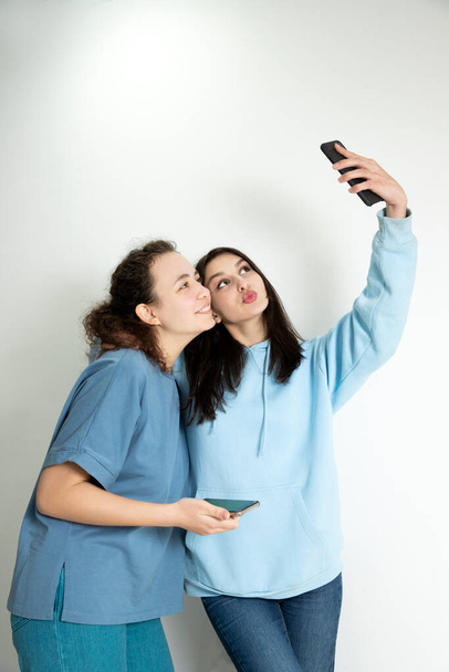 Die Mädchen machen ein Selfie. Models posieren für die Handykamera, Platz für Text - Foto, Bild