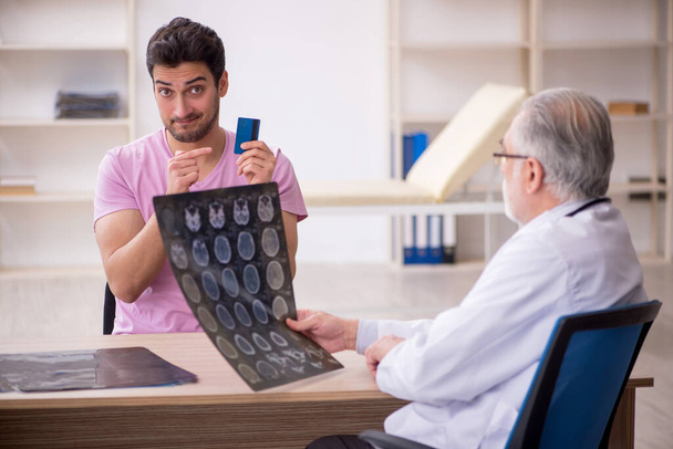 Paciente joven que visita al viejo radiólogo médico - Foto, imagen
