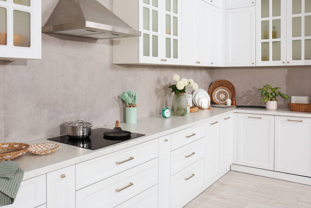 Beautiful kitchen interior with modern cooktop and stylish furniture - Zdjęcie, obraz